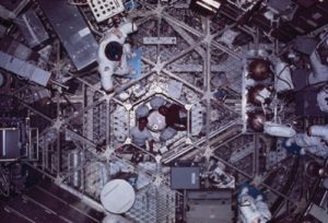Астронавты Гибсон и Карр выглядывают в восьмиугольное отверстие, которое связывает два уровня рабочего отсека